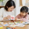 幼児と母親が手作りカードと絵本で楽しく英語にふれる家庭の場面