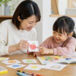 幼児と母親が手作りカードと絵本で楽しく英語にふれる家庭の場面