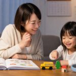 幼児が英語レッスン後に母親と家で絵本やおもちゃを使って復習する場面