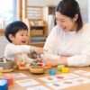 幼児が母親とおままごとやカード遊びをしながら英語にふれる家庭の場面