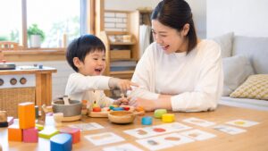 幼児が母親とおままごとやカード遊びをしながら英語にふれる家庭の場面