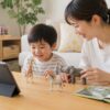 英語動画を見たあとに母親と動物のおもちゃで英語遊びをする幼児の家庭の場面