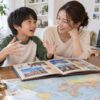 海外の思い出の写真を見ながら母親と話す小学生のイメージ