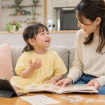 英検Jr.後に幼児が母親と絵本やタブレットで英語を声に出している写真