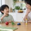 父親と小学生の子どもがおもちゃを使って言葉を思い出す遊びのイメージ