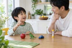 父親と小学生の子どもがおもちゃを使って言葉を思い出す遊びのイメージ