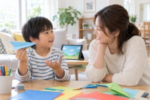 動画を止めて親子で紙飛行機を作りながらやりとりするイメージ