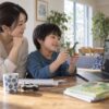 親のそばで好きなおもちゃを画面の先生に見せる子どものイメージ
