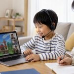 小学生がヘッドセットを使ってゲーム英語を楽しみながら母親が見守る場面