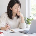 パソコンと予定表を見ながらレッスンの予定を考える母親のイメージ（AI生成）