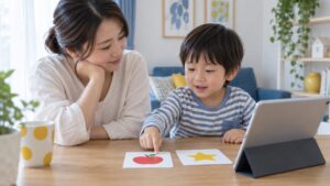 親子が絵カードを見ながらオンライン学習を相談するイメージ（AI生成）