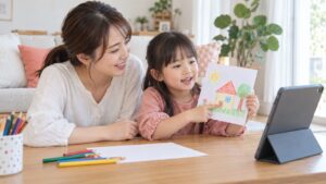 母親と一緒に描いた絵を画面の先生へ見せる幼児のイメージ（AI生成）