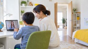 子ども部屋でオンライン英会話をする子に母親が付き添うイメージ（AI生成）