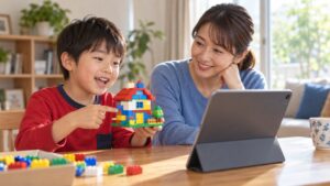 母親と子どもが手作りのブロックの家を画面に見せるイメージ（AI生成）