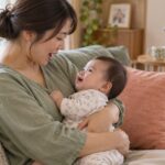 母親が赤ちゃんを抱き歌いかける家庭のイメージ（AI生成）
