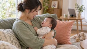 母親が赤ちゃんを抱き歌いかける家庭のイメージ（AI生成）