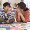 母親と二人でおもちゃのマイクを使って遊ぶ幼児のイメージ