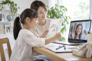 母親が見守る家の机で、海外の友だちに絵を見せる小学生のイメージ