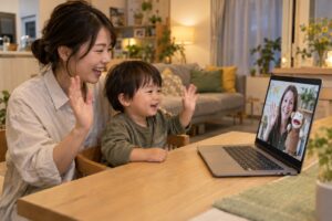 仕事帰りの母親と幼児が一緒に画面の先生へ手を振る家庭のイメージ
