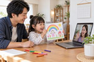 父親の隣でオンラインの先生に描いた絵を見せる幼児のイメージ（AI生成）